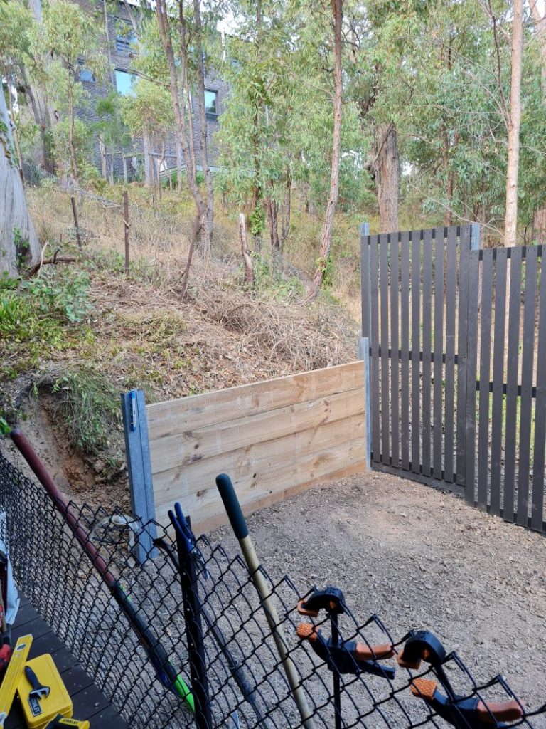 Wooden retaining wall with steel posts