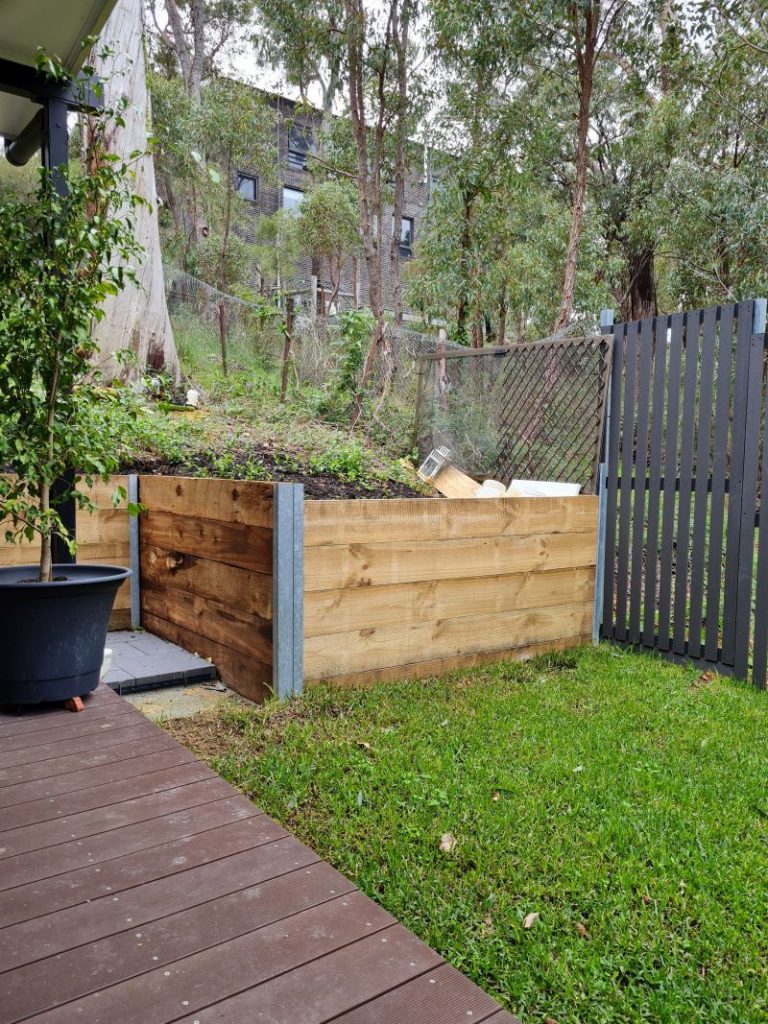 Grey garden screen installed and wood panel retaining wall started